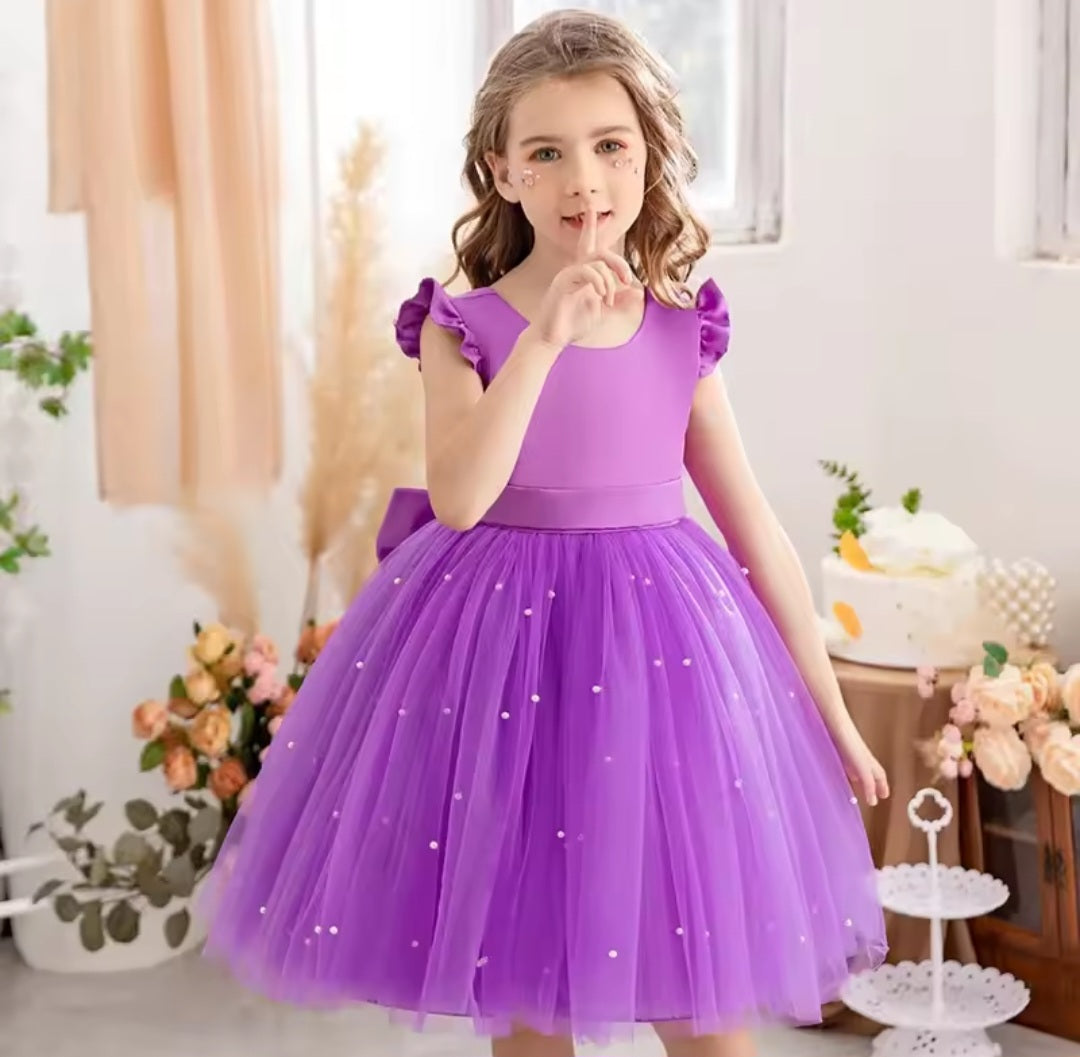 Vestido lila, perlas, moño
