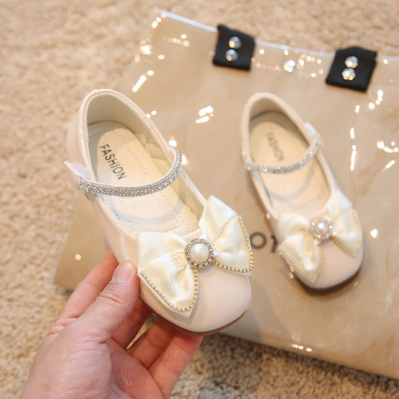 Calzado beige, perlas, moño